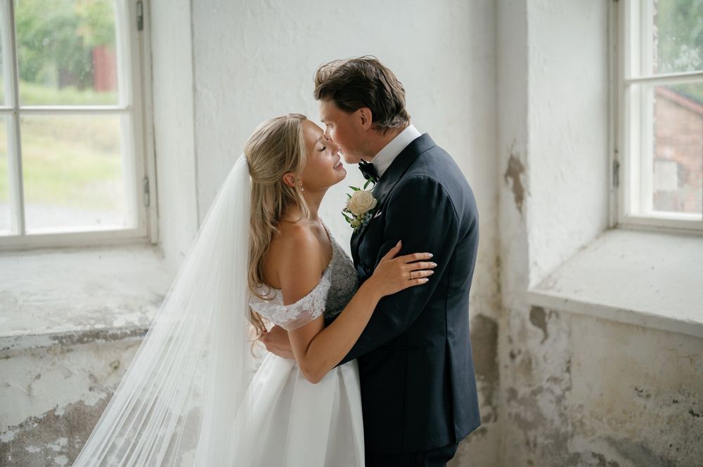 Tender moment between wedding couple in naturally lit vintage interior.
