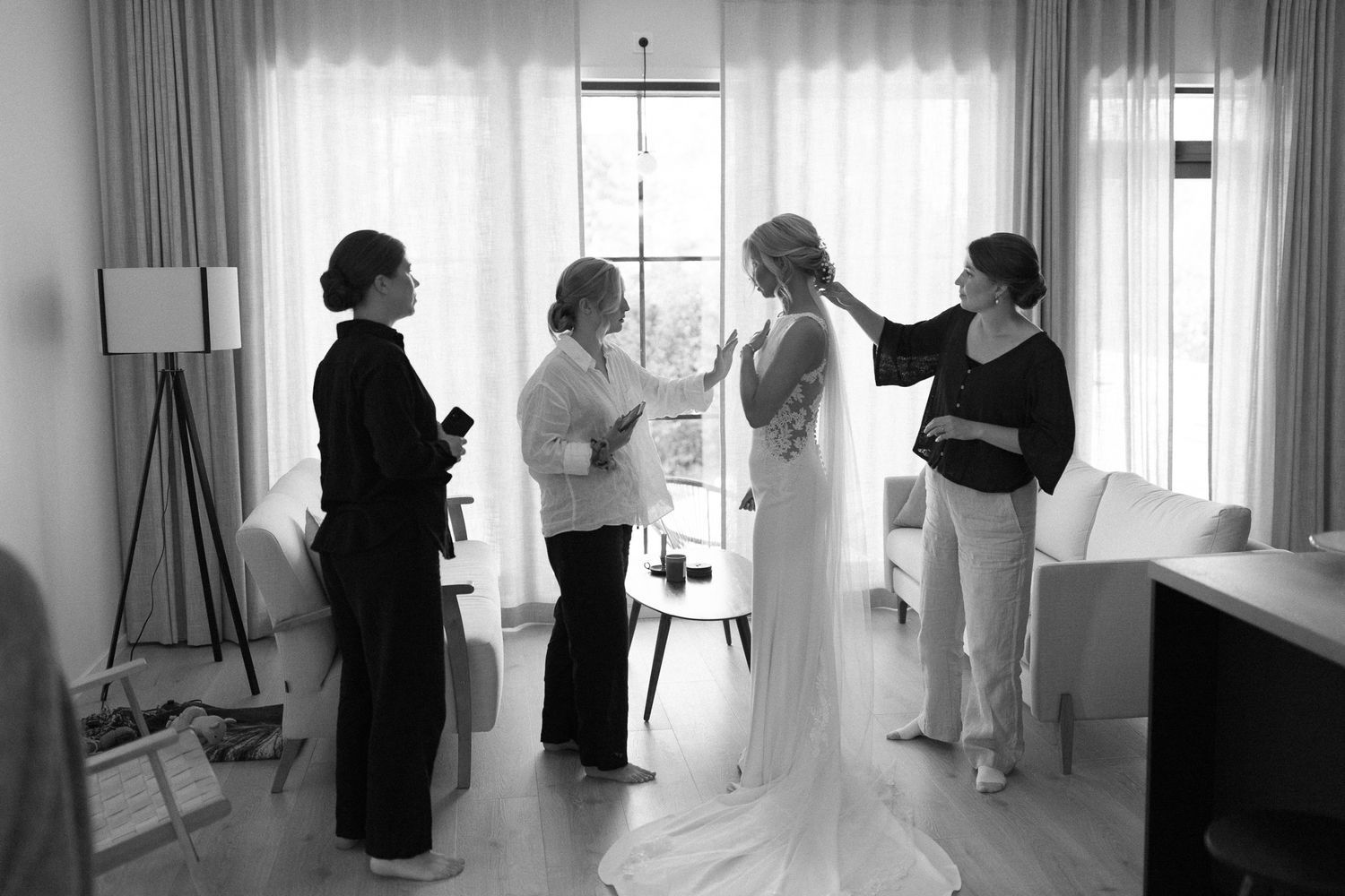 Wedding preparations in bright room with window light and silhouettes.