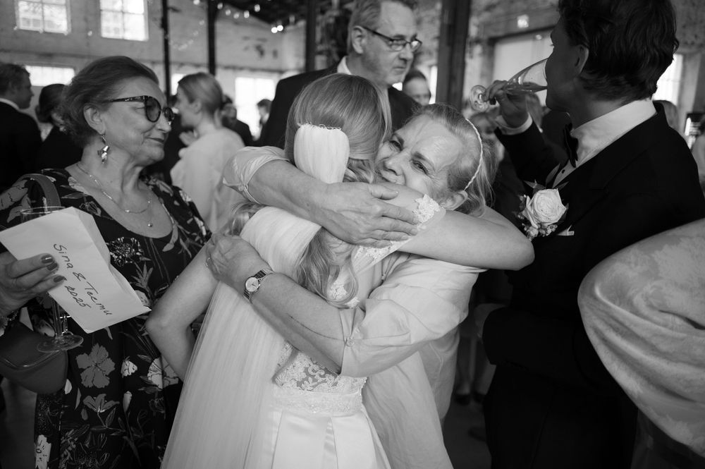 Wedding guests embrace during an emotional moment at the reception.