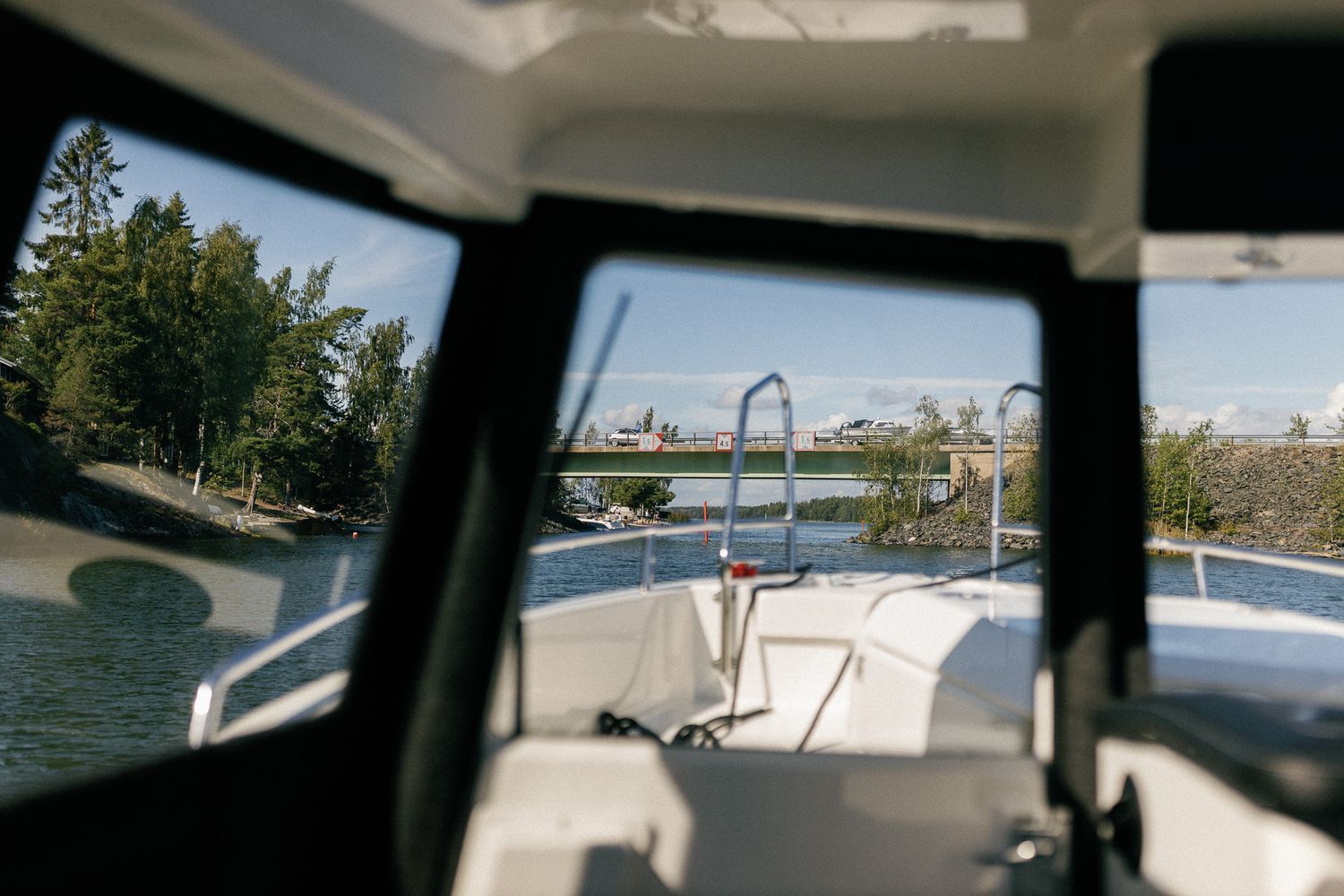 Interior view of a boat cabin looking out towards a lake and dock.