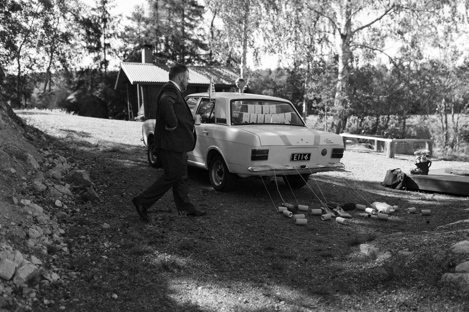 Black and white photograph of vintage cars parked near a lakeside.
