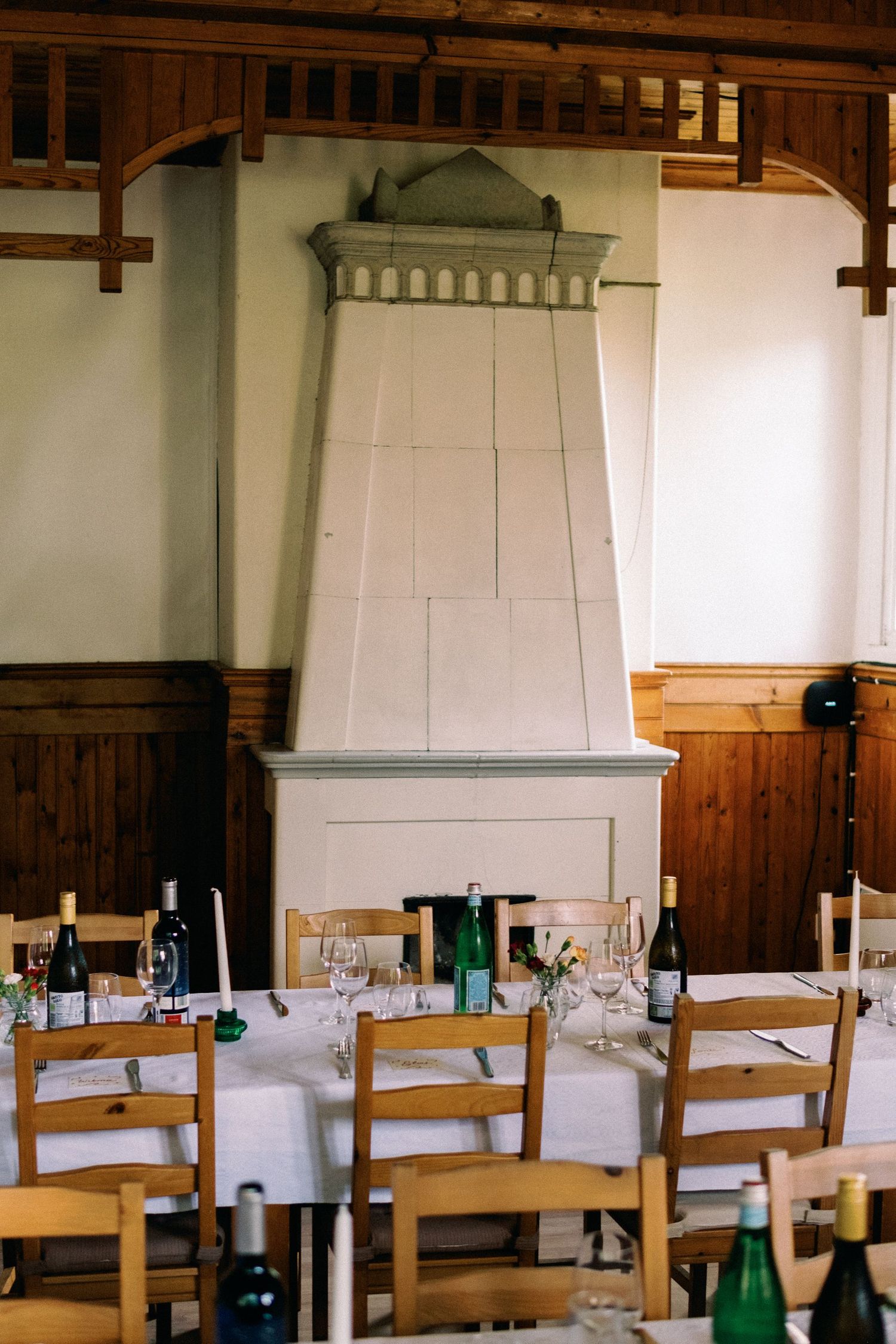 Elegant dining room interior with wooden chairs and a distinctive white fireplace mantel.