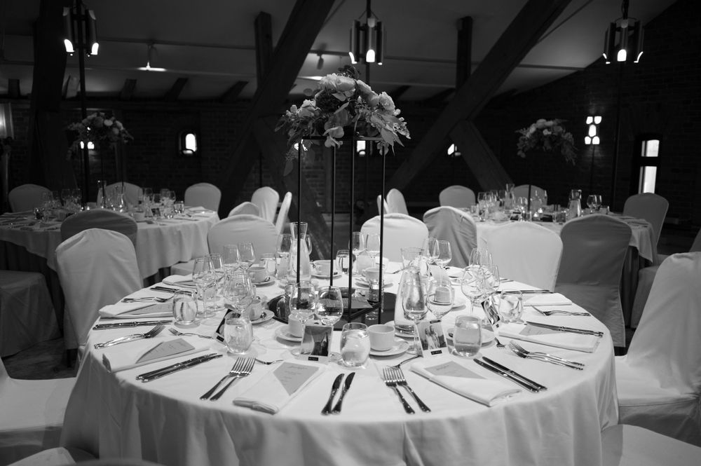 Elegant wedding reception tables set with white linens and centerpieces.
