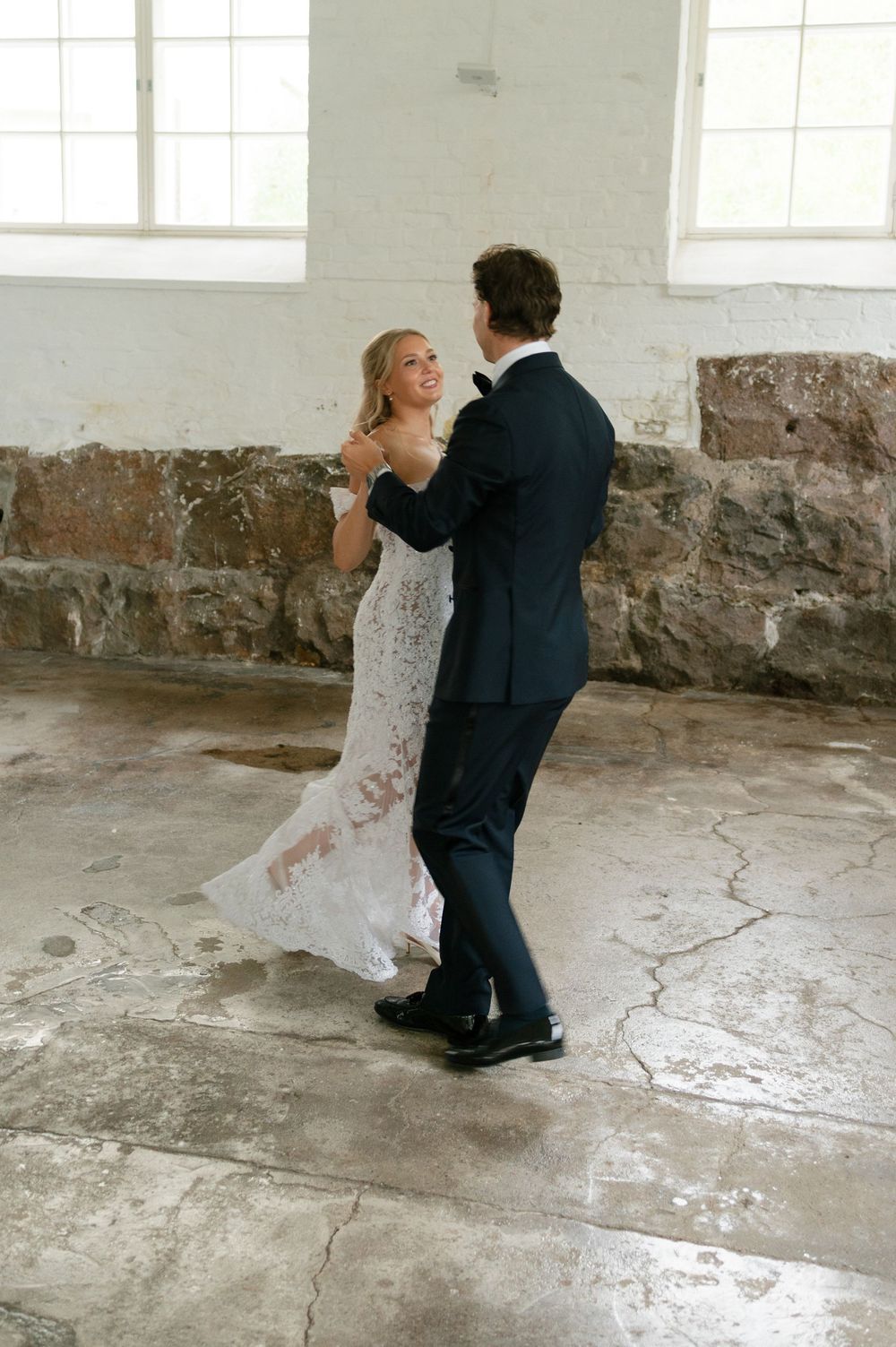 A romantic dance sequence captured in a minimalist industrial space with natural lighting.