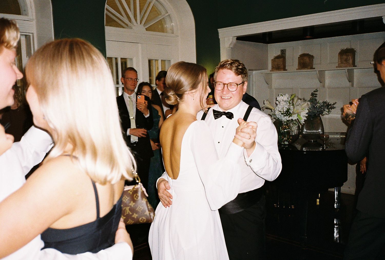 Formal event space with guests dancing and mingling in evening attire.