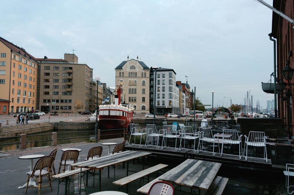 Harbor view with boats and apartment buildings along the waterfront on a cloudy day.
