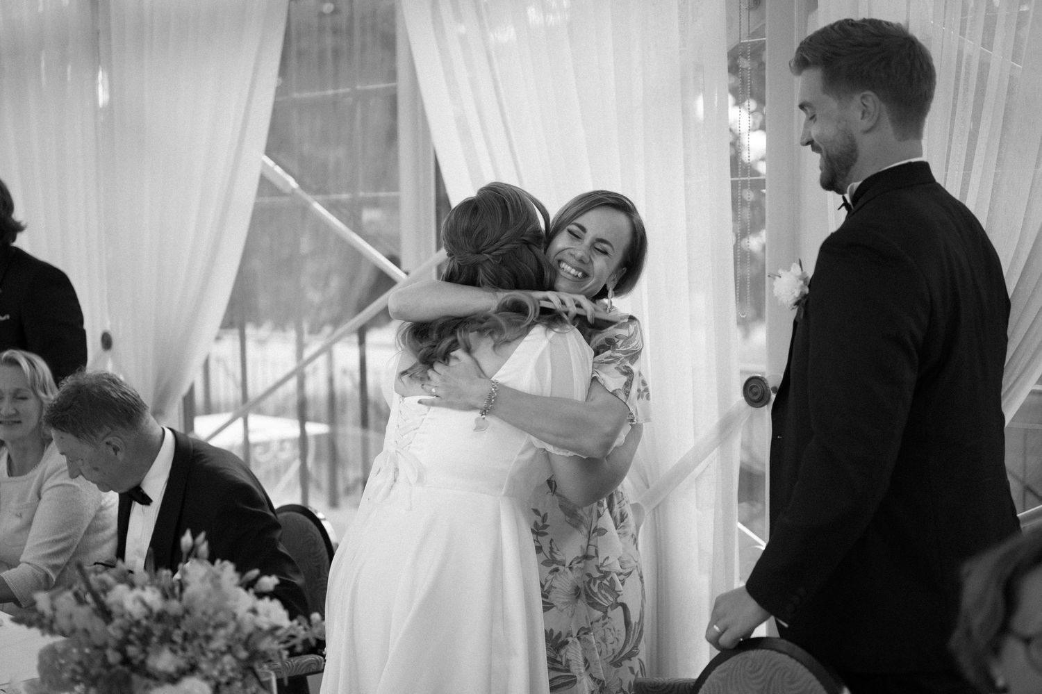 Intimate moments captured during a wedding reception with elegant white drapery.