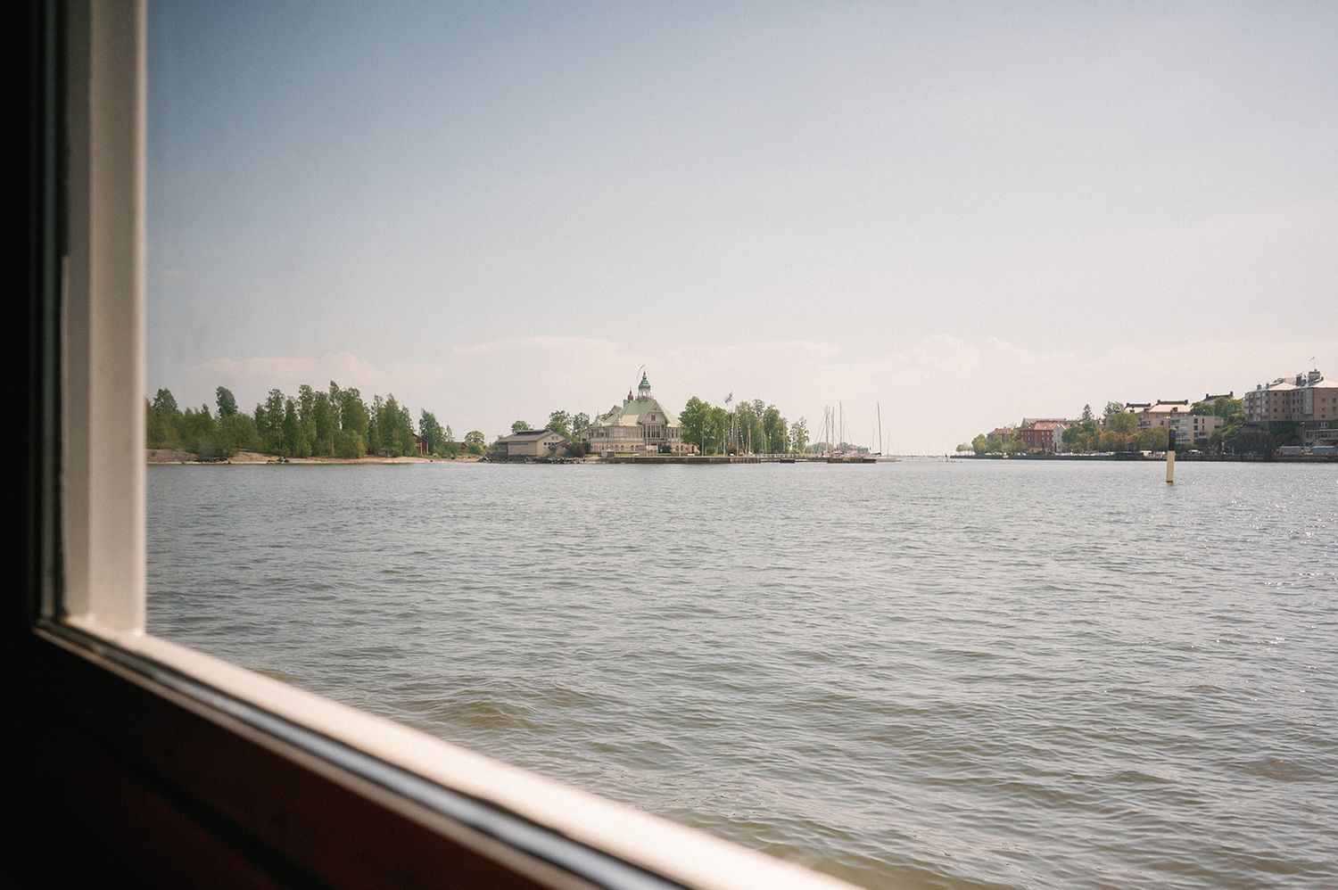 Scenic waterfront view with distant buildings and trees on the horizon.