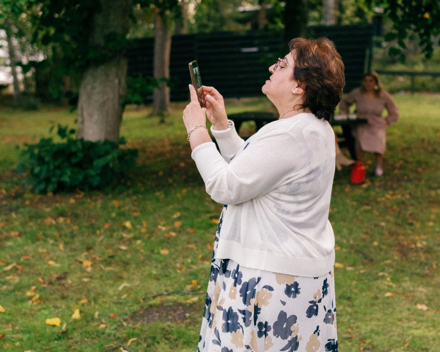 Guest taking photos with a phone camera during an outdoor event.