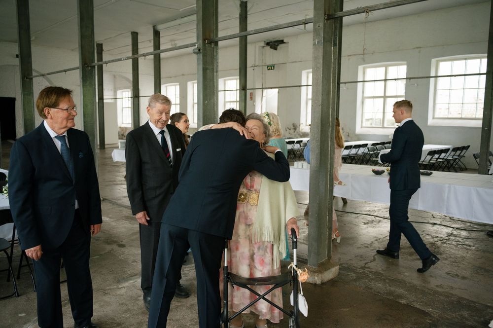 Wedding ceremony setup in a rustic industrial space with exposed brick walls and large windows.