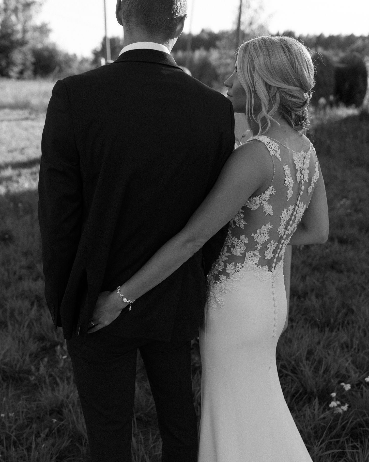 Black and white detail shot of bride's lace back wedding dress.