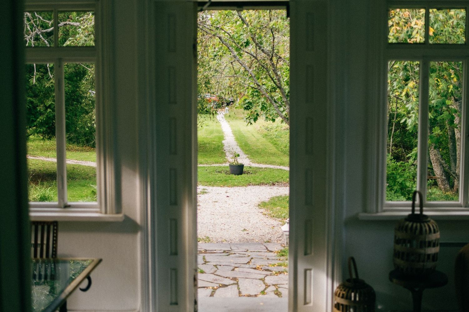 Interior view of a bright room with large windows overlooking a garden.
