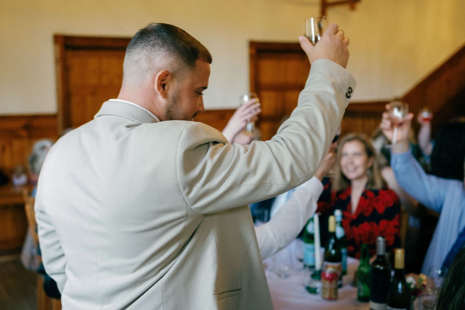 Guests celebrating with raised arms in a traditional reception venue.