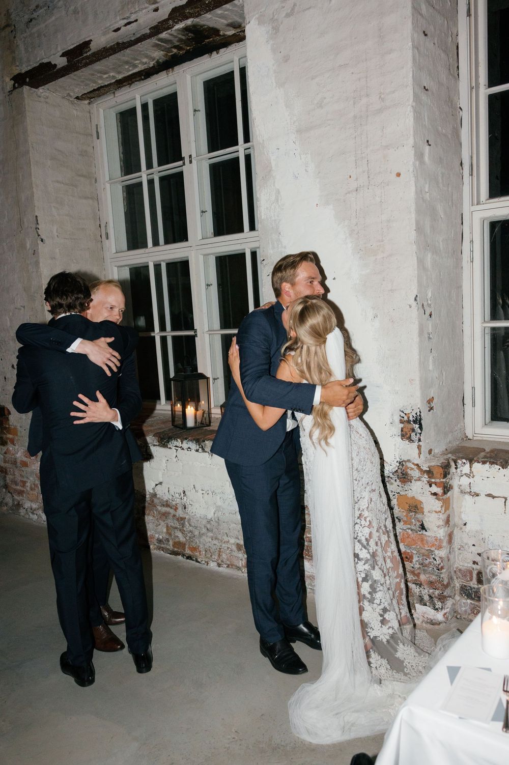 Wedding celebration in an industrial venue with exposed brick walls and white decor.