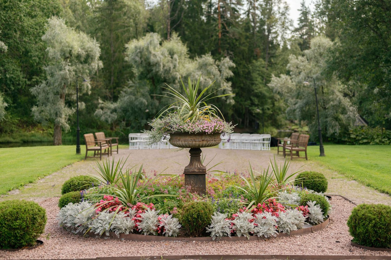 Lush garden path with colorful flower beds and landscaping at an outdoor wedding venue.