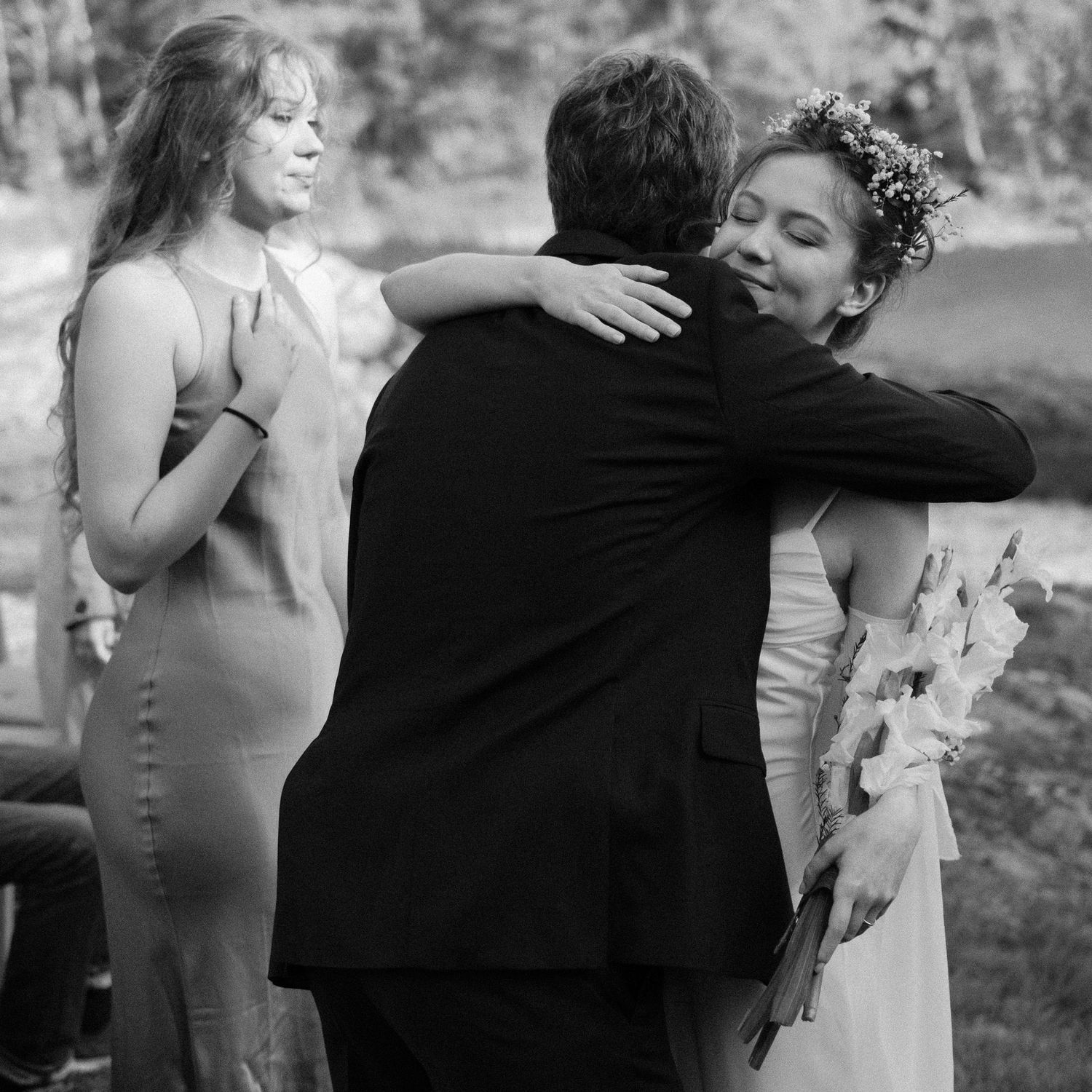 Candid black and white sequence of wedding celebration embraces.