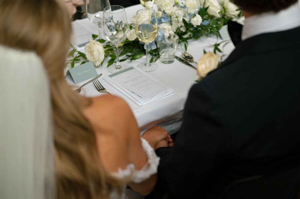 Elegant white floral centerpiece arrangement on a wedding reception table.