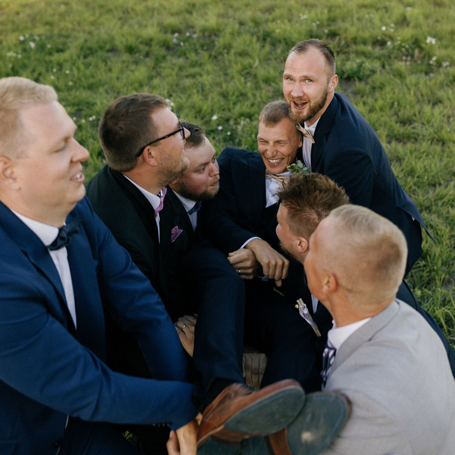 Wedding party members perform choreographed mock combat scene in navy suits.