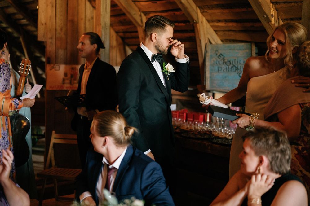 Wedding guests mingling and laughing during an indoor reception celebration.