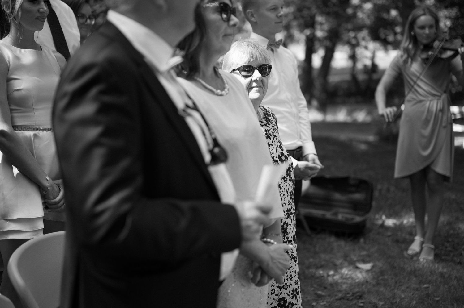 Black and white candid moments from an outdoor wedding ceremony.