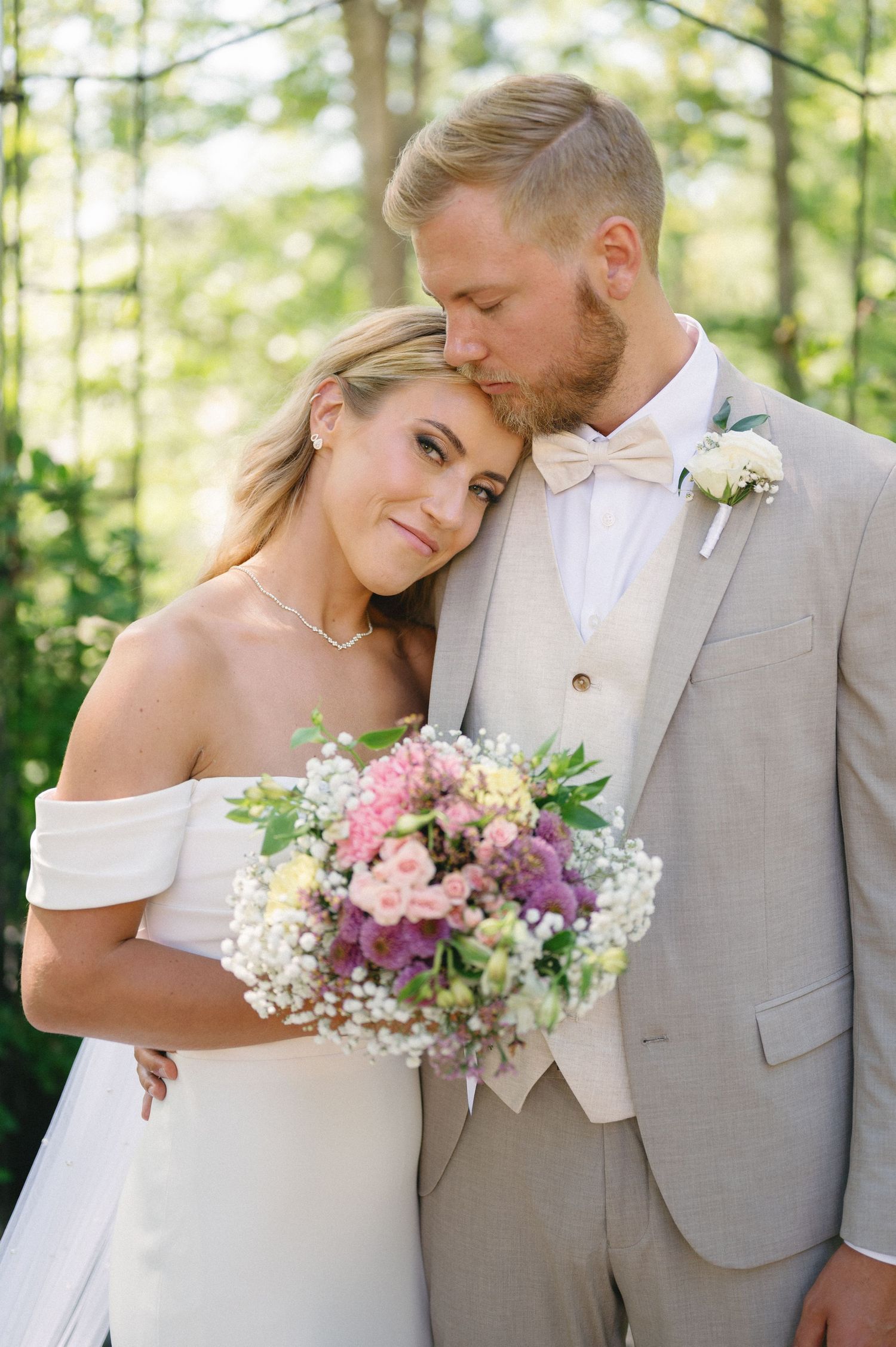 Intimate wedding portraits with soft pastel bouquets in natural lighting.
