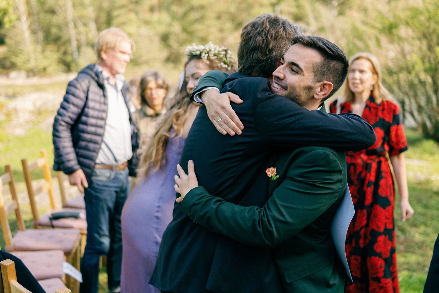 An emotional embrace shared during an outdoor wedding celebration with guests looking on.