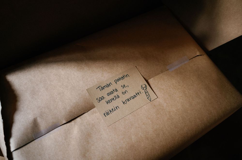 Artistically lit kraft paper packages with handwritten text in moody lighting.