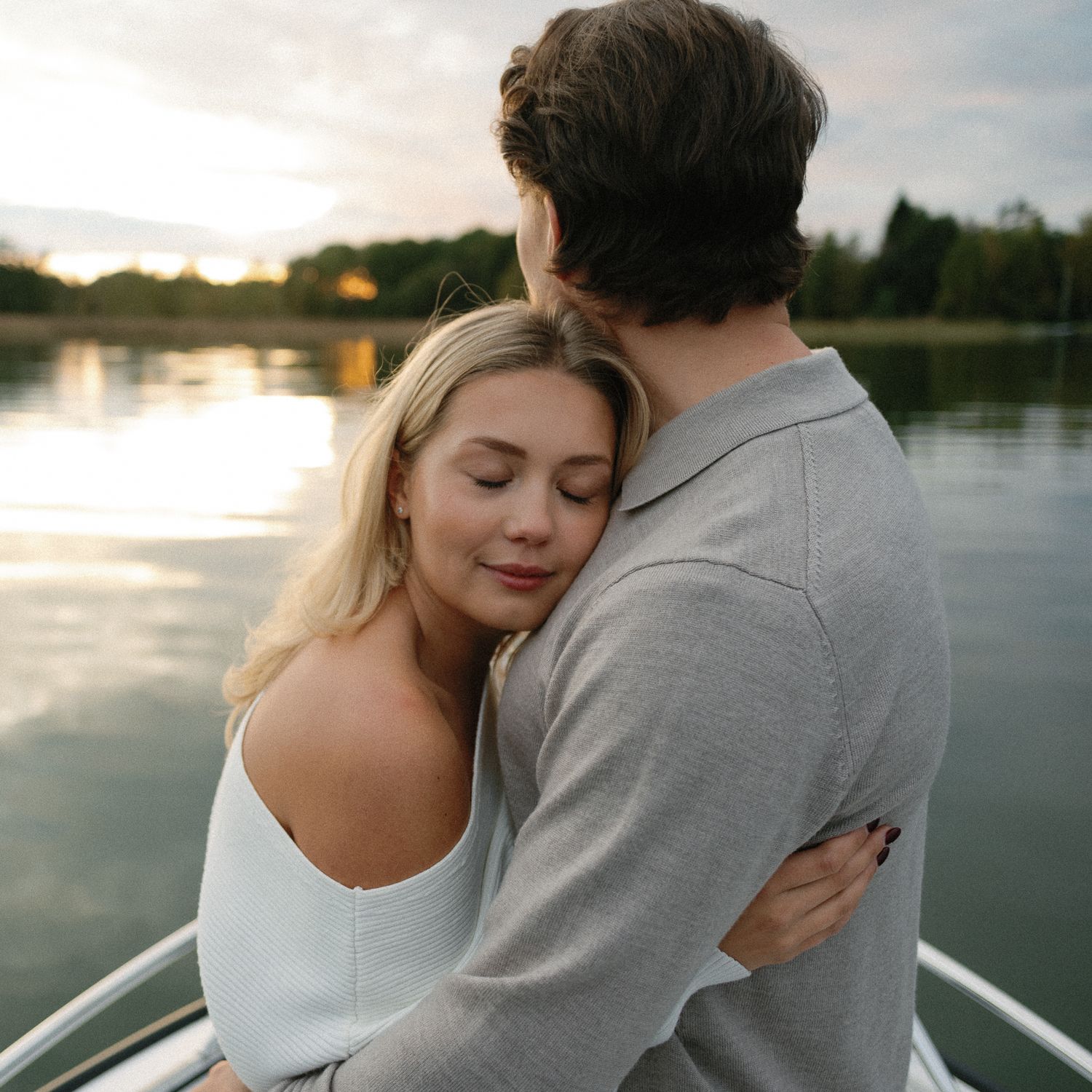 Tender moments captured between a couple on a boat at sunset.
