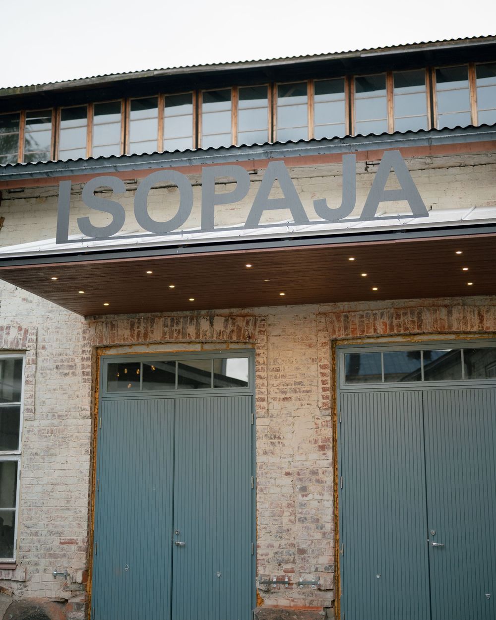 Exterior view of an industrial building with blue doors and ISOPAJA signage.