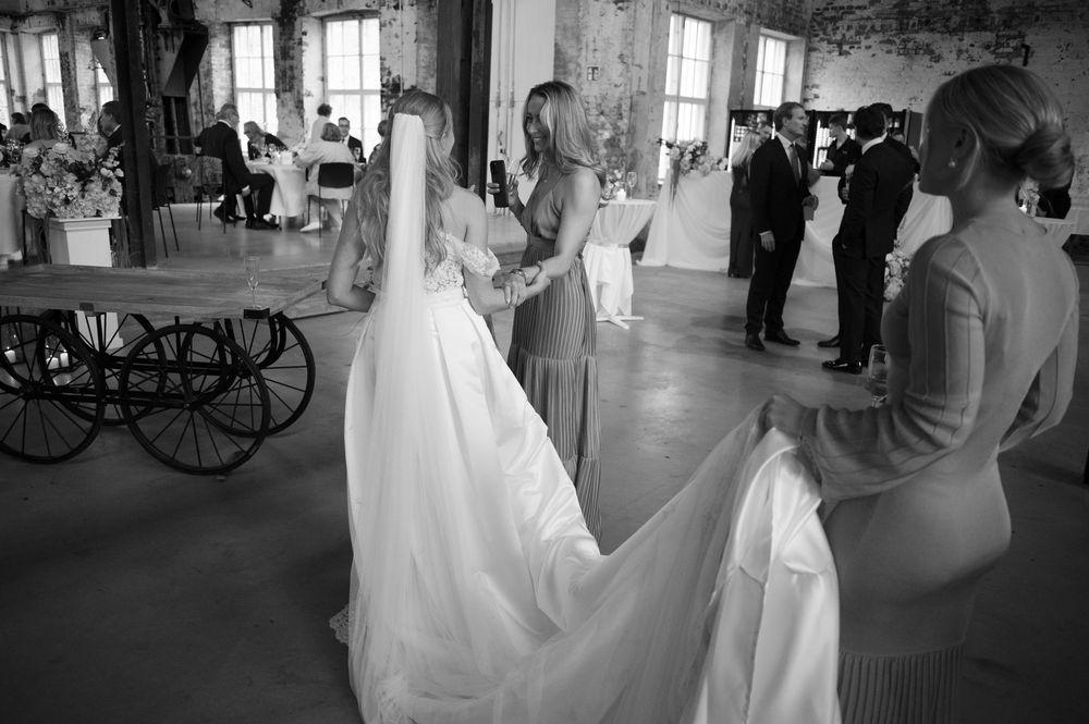 Wedding celebration in a rustic brick-walled venue with guests mingling.