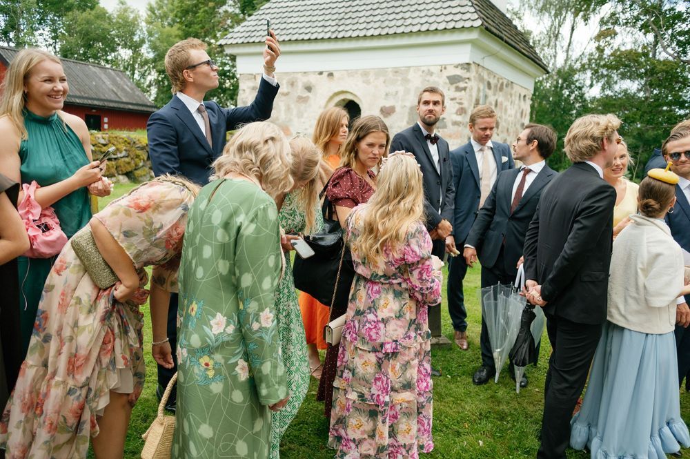 Wedding guests mingling outdoors in colorful summer attire.
