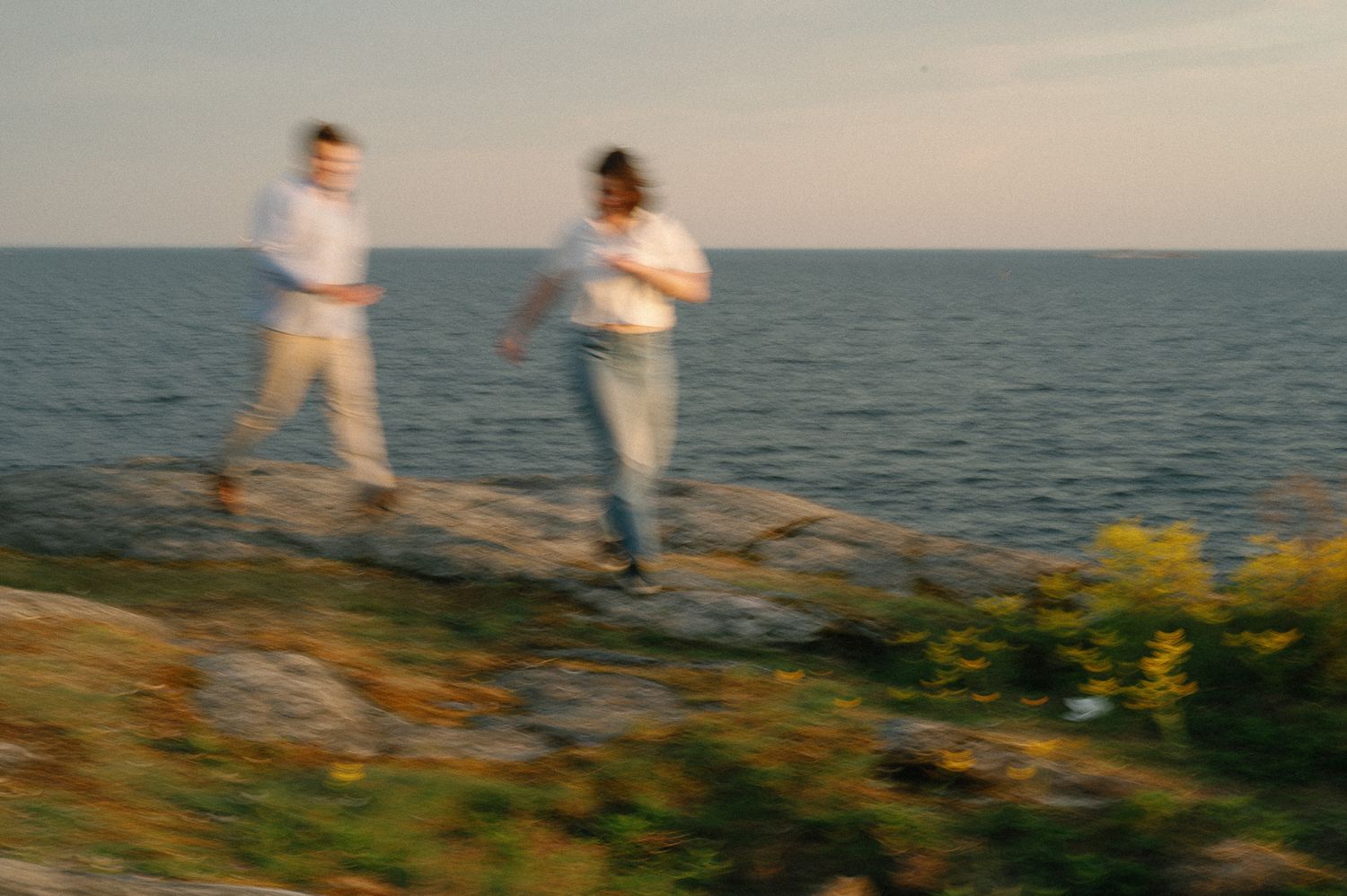 Couple walking along a coastal path at sunset with ocean views.