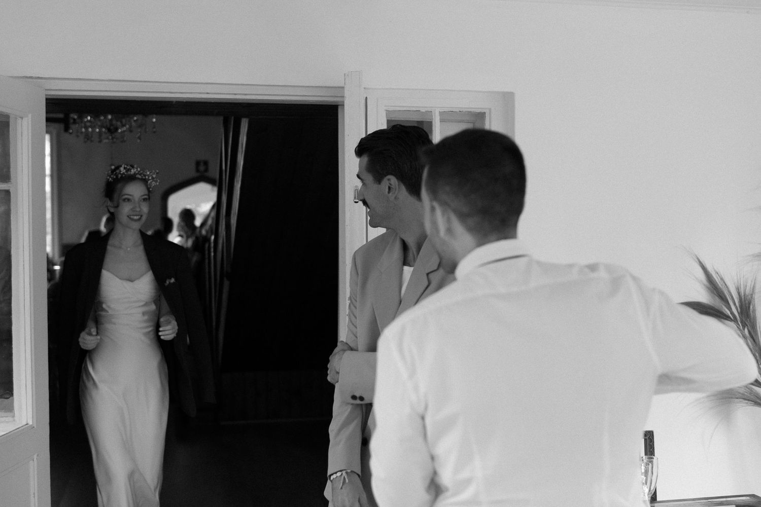 Black and white photo showing silhouettes of people walking through a hallway.