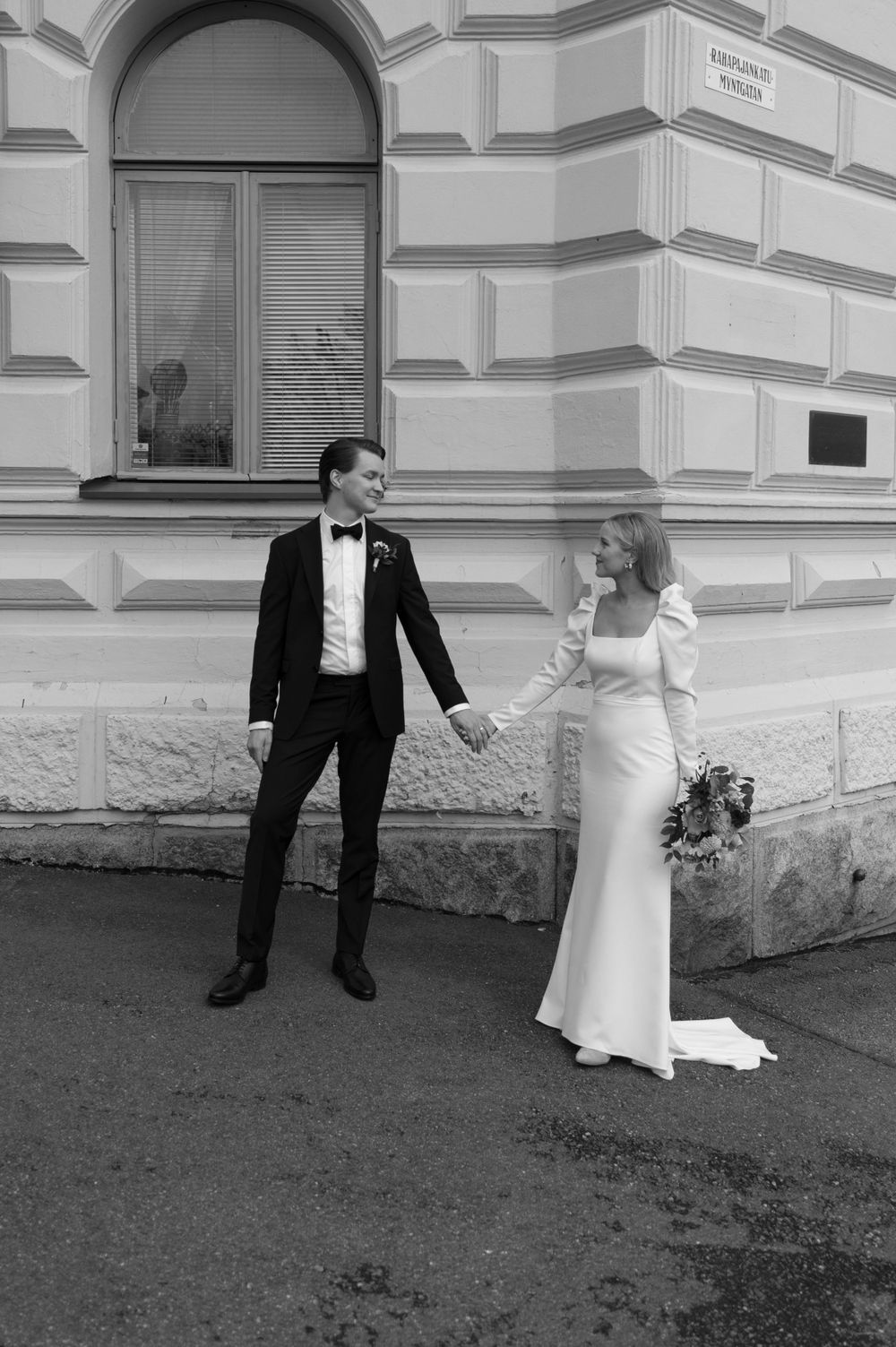 Black and white wedding portraits taken against a classic building exterior.