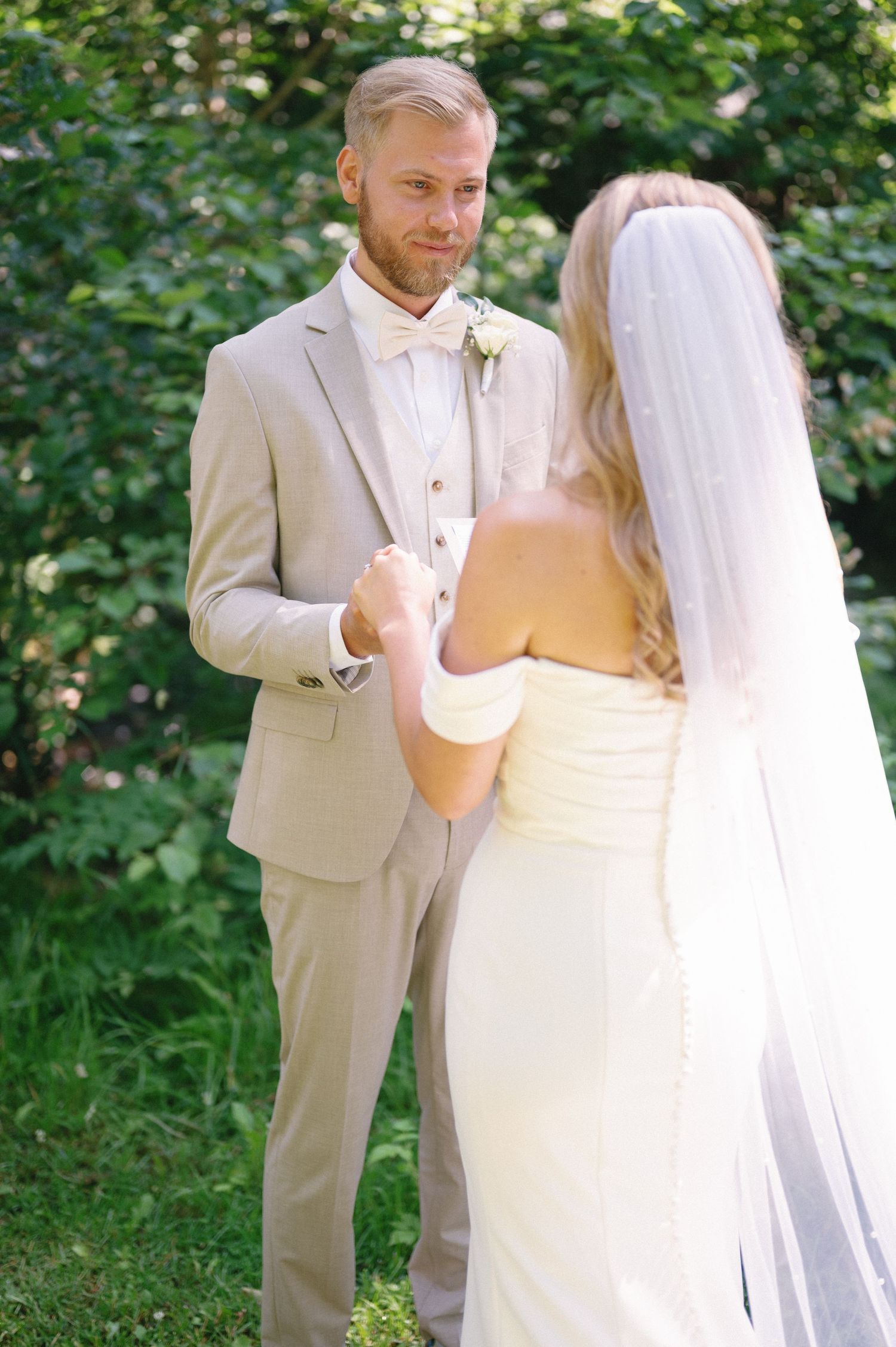 Wedding couple exchanges emotional vows in an outdoor garden ceremony.