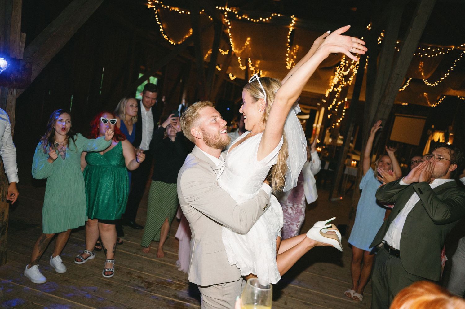 Wedding celebration on dance floor with string lights decorating the ceiling.