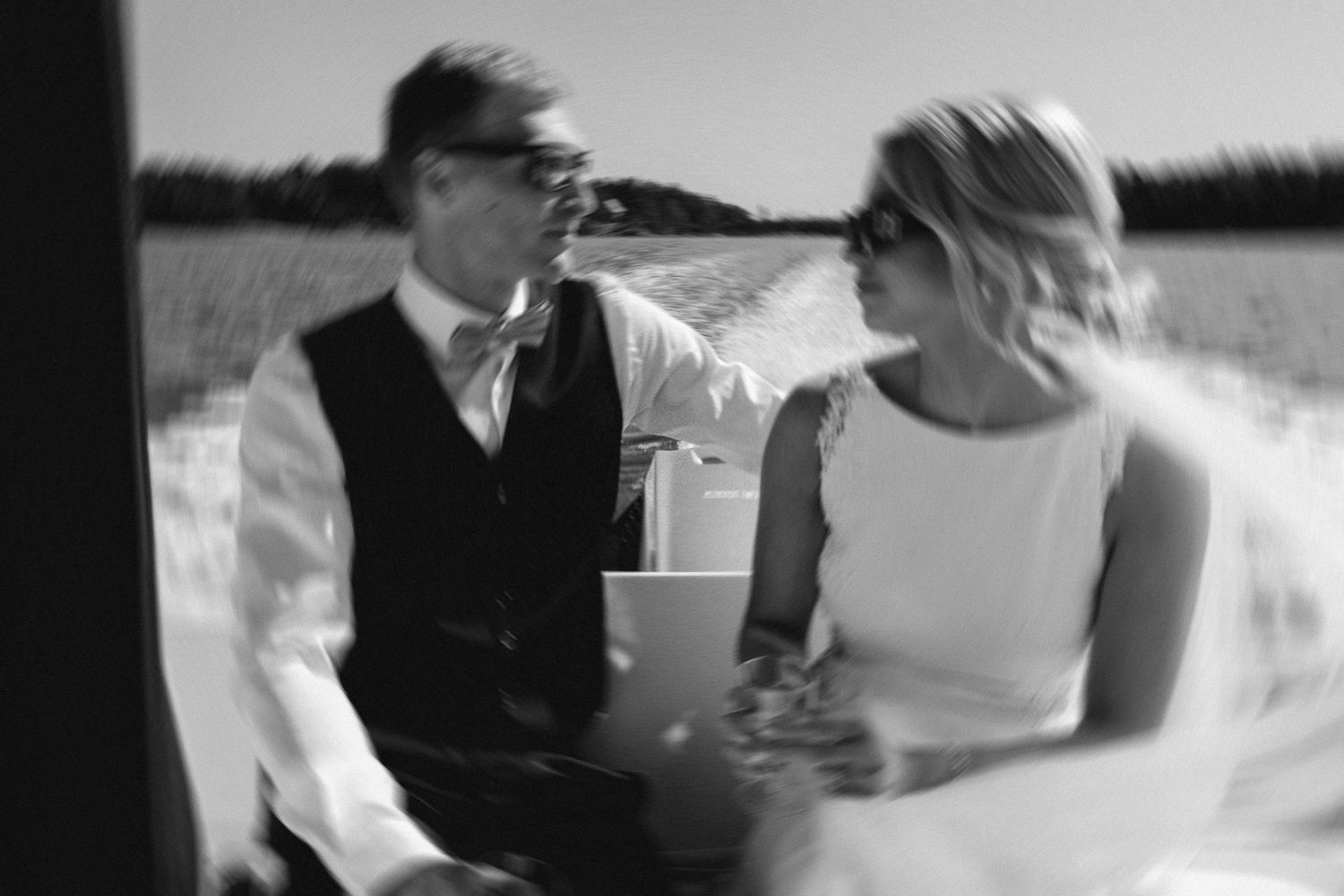 Black and white photo of a couple sharing drinks on a boat.