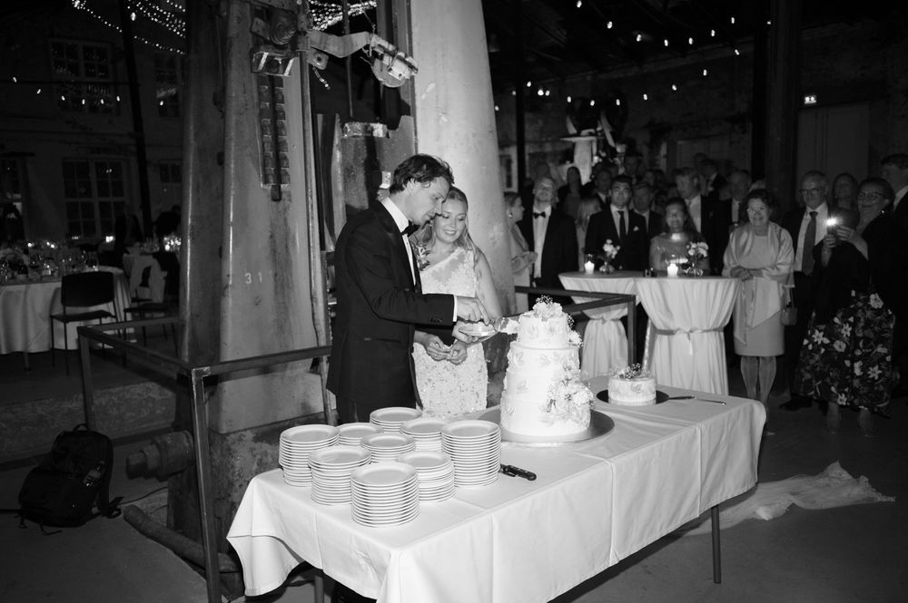 Black and white photo of a wedding reception setup with elegant table settings and ambient lighting.