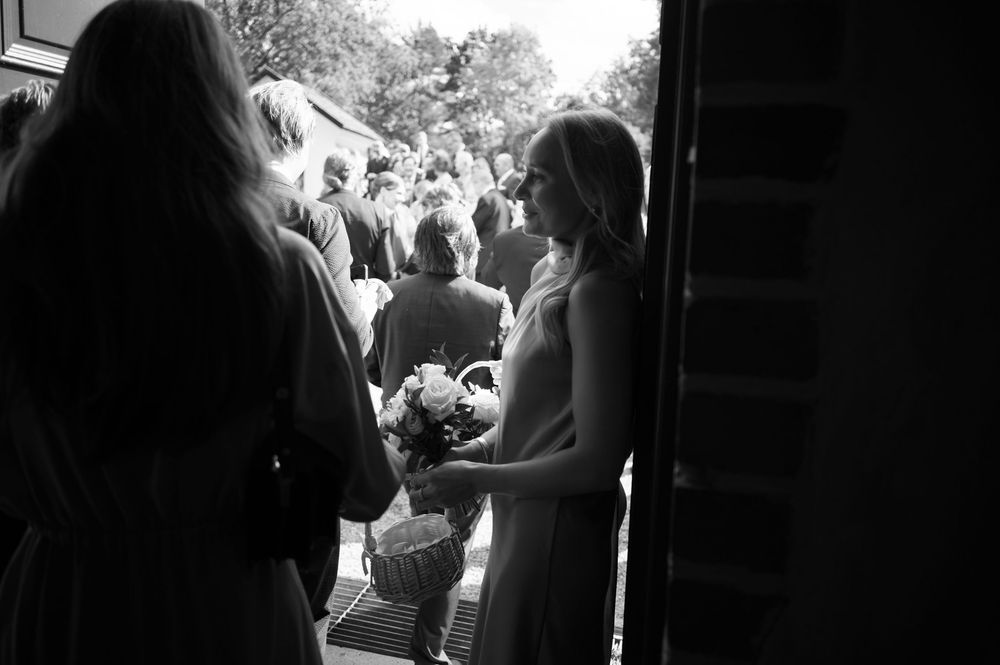 Silhouetted wedding guests gathering outside church doors.