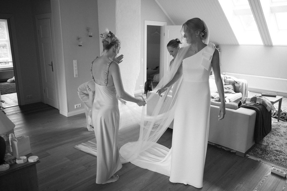 Series of candid moments during wedding dress preparations in bright indoor space.