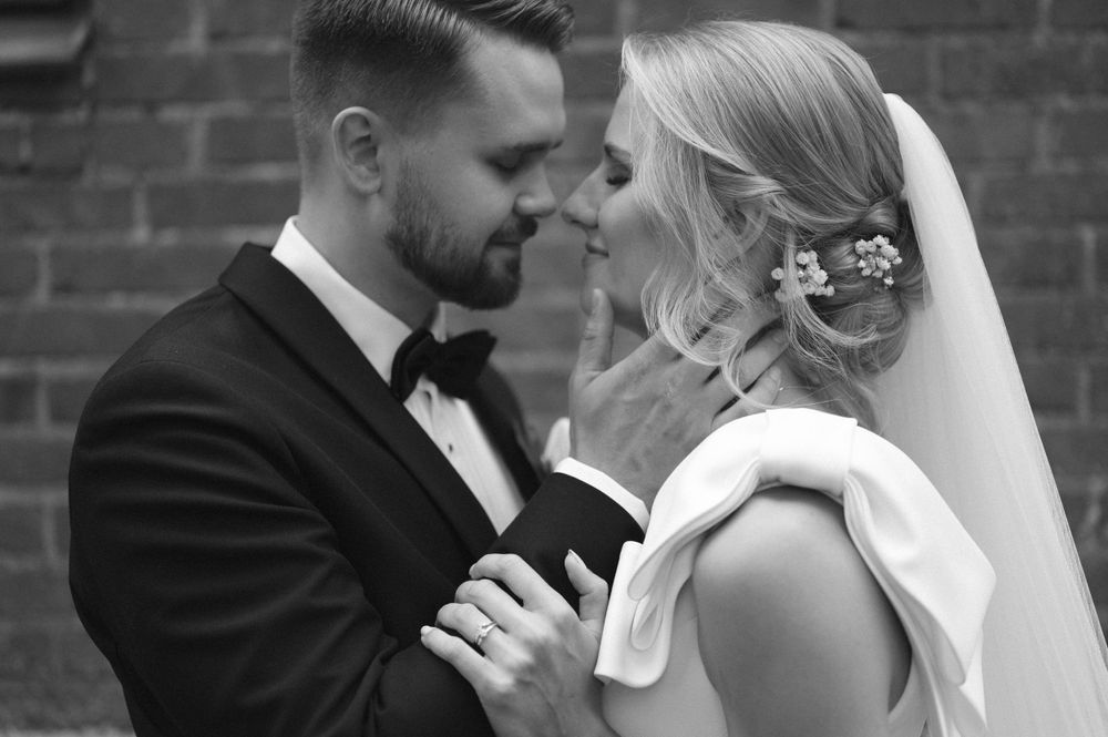 Romantic wedding sequence against brick wall backdrop showing intimate moments between newlyweds.