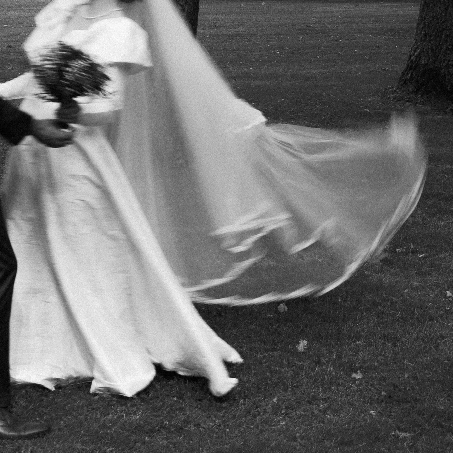 A flowing white dress billows in motion against a dark background creating an ethereal dancing effect.