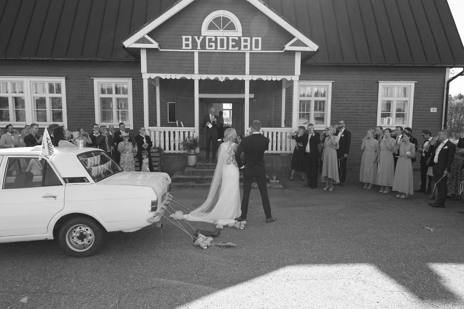 Wedding venue exterior with traditional architecture and gathering guests.