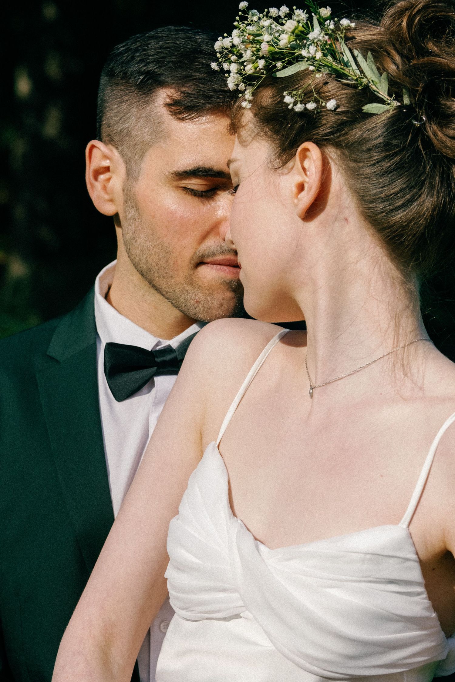Close-up wedding portraits showing intimate moments with delicate flowers in hair.