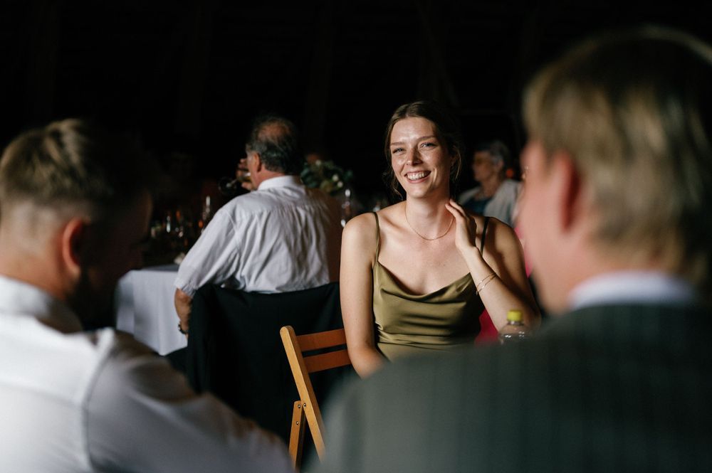 Guests seated at tables during an elegant indoor wedding reception with warm lighting.