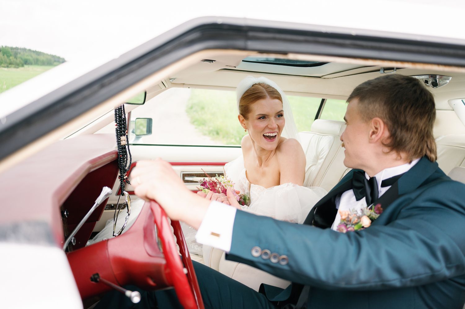 Interior view of a classic car with red leather seats and vintage dashboard details.