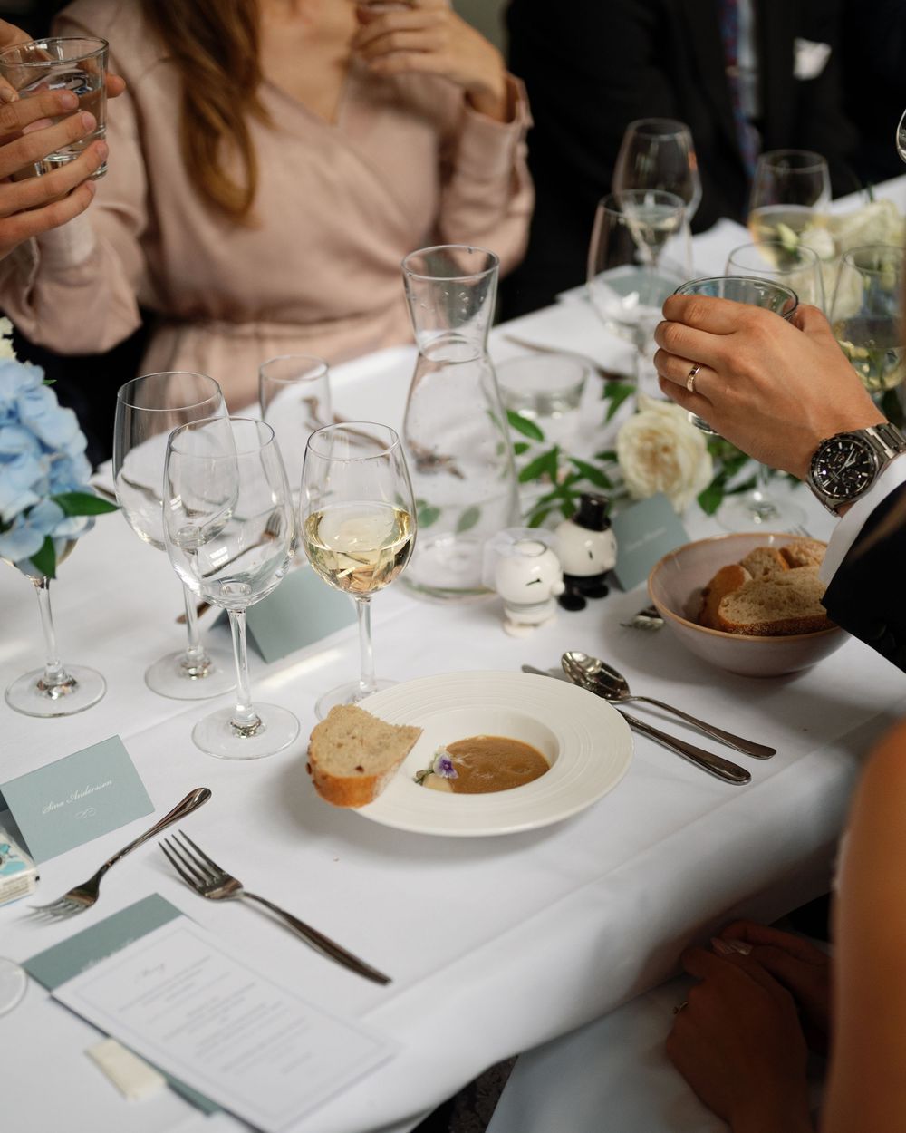 Elegant table settings with wine glasses and place cards at a formal dining event.