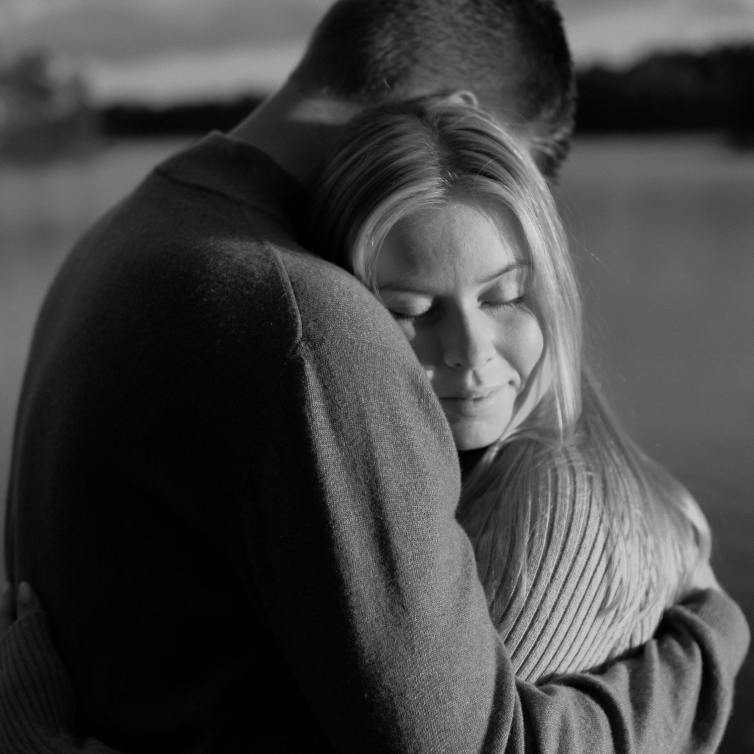 Black and white close-up shots of a tender embrace between two people.