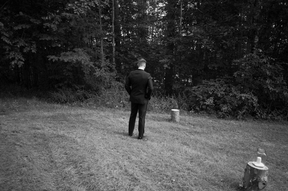 Black and white outdoor wedding ceremony setup with natural landscape backdrop.