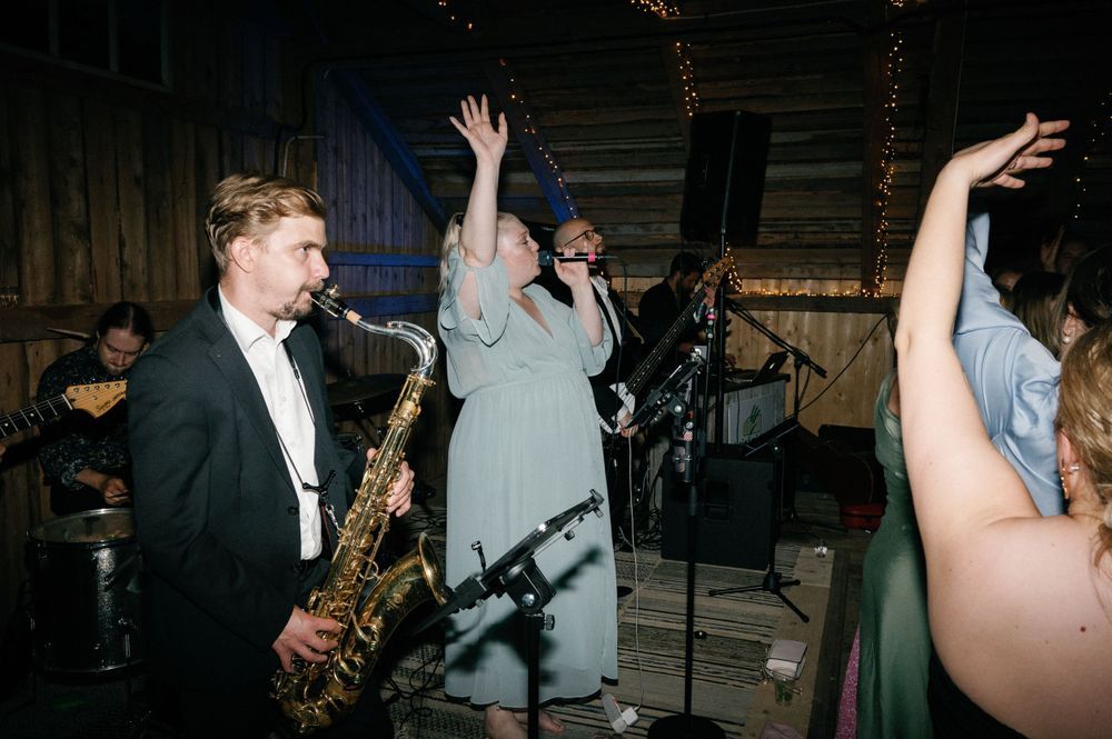 Energetic dance party scene at a wedding reception with guests moving to the music.